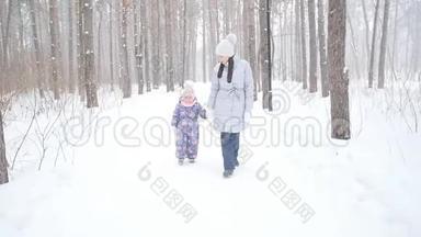 母亲和女儿在雪林或公园散步